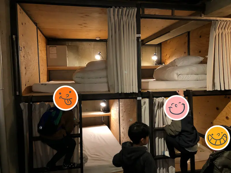 2段になった個室ベッドのはしごを登る4人の子どもたちの写真