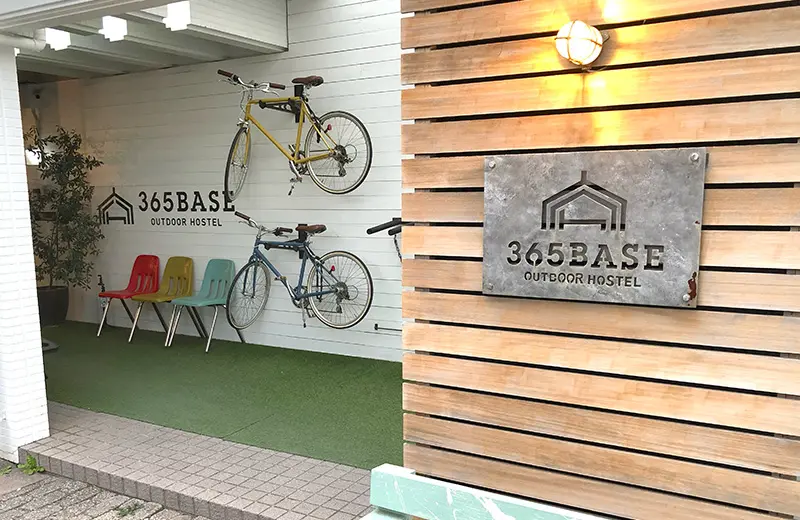 365BASE outdoor hostelの入口。カラフルなチェアや自転車が壁に飾ってある。