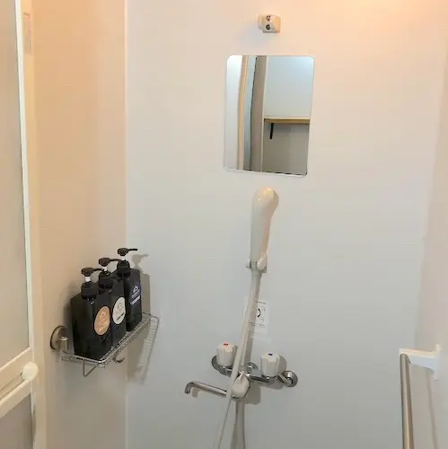 白を基調とした清潔感のあるシャワー室。シャンプー、リンス、ボディソープが用意してある