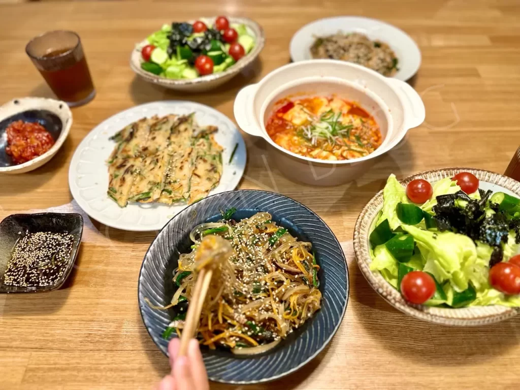 韓国料理コッキルのミールキット：ニラチヂミ、スンドゥブチゲ、チャプチェがテーブルに並んでいる様子