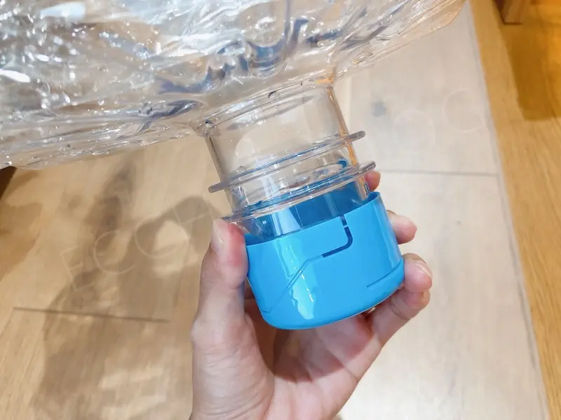 プレミアムウォーターの空きボトルの写真。青いキャップが剥がせるように切り込みが入っている。